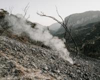 Smoky, rocky, barren mountain with dead trees