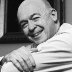 A man in a white shirt leaning on his elbows and smiling