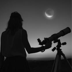person with long hair standing with telescope and looking at the moon