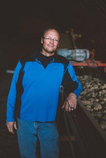 Wyatt standing next to a truck of potatoes for his headshot. 