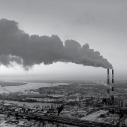 Two smokestacks billowing smoke across the sky.